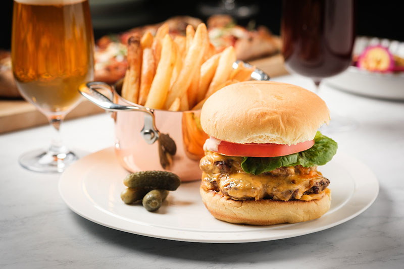 Burger, fries, and beer spread on table
