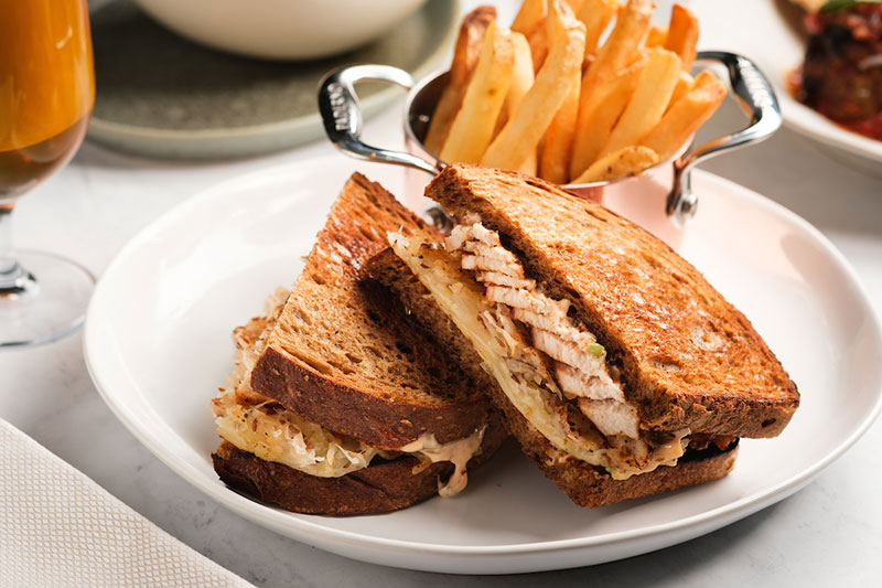 Image of sandwich, fries, and beer